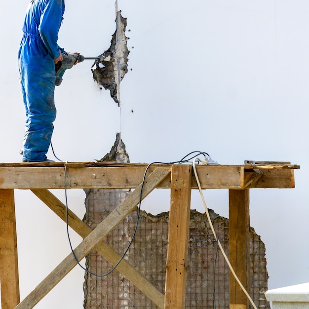 Construtor em funcionamento repara fachada de edifício antigo