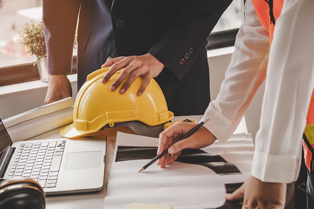 Construtor jovem engenheiro e mulher arquiteta estão discutindo a construção de um plano para seguir o projeto para construir uma planta industrial no local Conceito de trabalhador