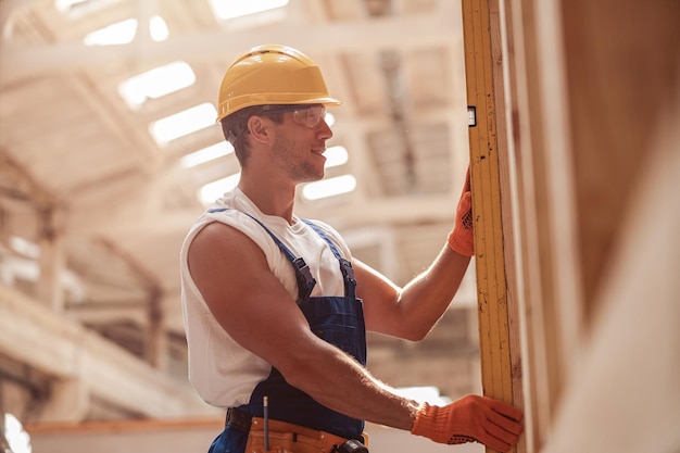 Construtor masculino alegre trabalhando em canteiro de obras