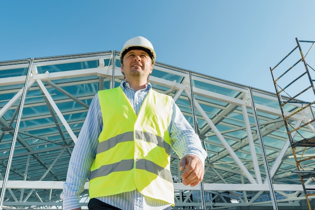 Construtor masculino andando para a frente no telhado do canteiro de obras