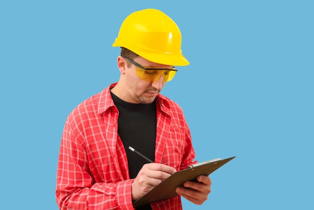 Construtor ou trabalhador em um capacete de construção em um fundo azul