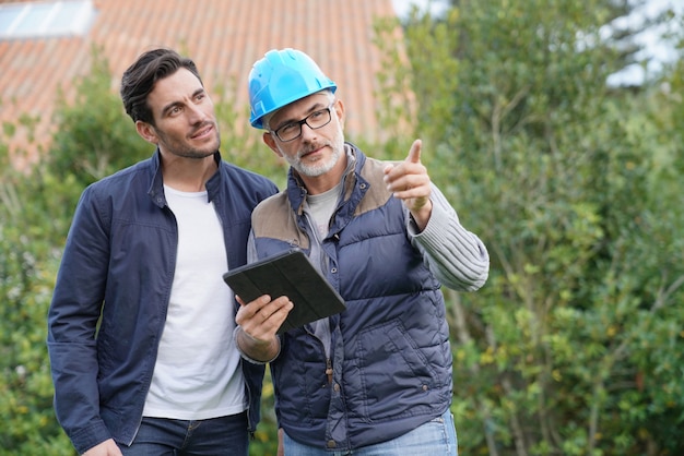 Construtor passando por planos ao ar livre com os proprietários