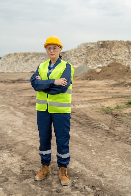 Construtora contemporânea de roupas de trabalho em pé no canteiro de obras