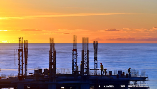 Construyendo sueños Foto gratis de trabajadores de la construcción al atardecer Testigos del arte del progreso