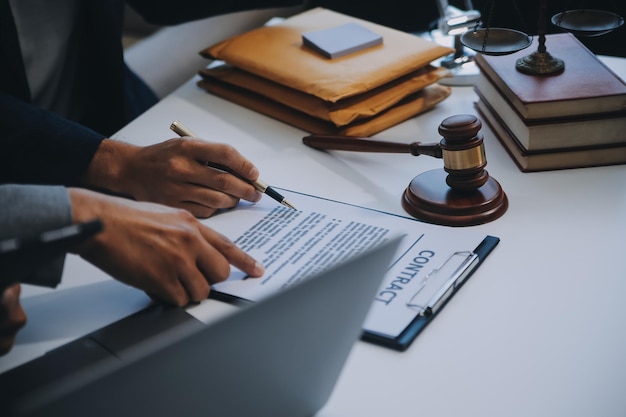 Foto consulta y conferencia de abogados masculinos y empresarias profesionales que trabajan y discuten en un bufete de abogados en la oficina conceptos de derecho juez martillo con balanza de justicia