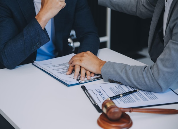 Foto consulta y conferencia de abogados masculinos y empresarias profesionales que trabajan y discuten en un bufete de abogados en la oficina conceptos de derecho juez martillo con balanza de justicia