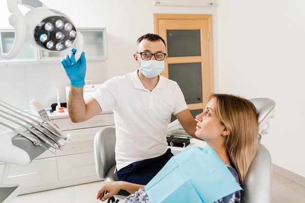 Consulta con el dentista en odontología Tratamiento dental El dentista examina la boca y los dientes de la niña y trata el dolor de muelas Mujer feliz paciente de odontología