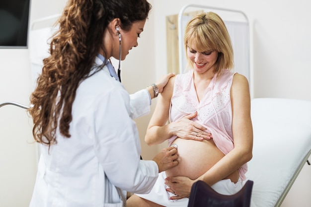 Foto consulta e exame ginecológico. mulher grávida com seu médico na clínica.