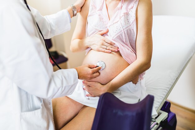 Foto consulta e exame ginecológico. mulher grávida com seu médico na clínica.