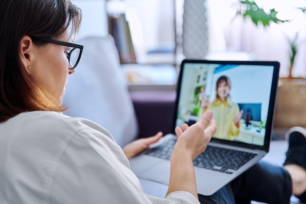 Consulta en línea maestra mentora hablando con una estudiante adolescente Tecnología de conferencia de chat de videollamada en la sesión de reunión virtual de educación