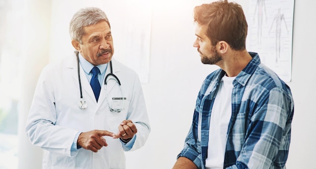 Consulta con el médico y el hombre para la atención médica con la conversación y el diagnóstico del paciente en la clínica Ayuda y comunicación hospitalaria para la medicina y la persona enferma resultados profesionales y médicos maduros