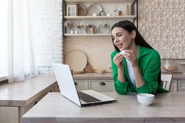 Consulta online com um psicólogo familiar, uma jovem linda na cozinha chora em