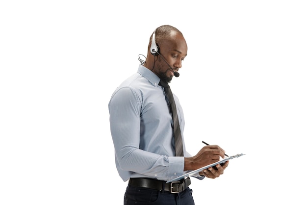 Consultor de centro de llamadas afroamericano joven con auriculares aislado sobre fondo blanco de estudio
