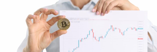 Consultor de criptomonedas tiene bitcoin y gráfico con indicadores financieros en la parte superior de las manos