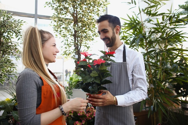 Consultor de homem dá flores em vaso para colega mostrar gostar dela