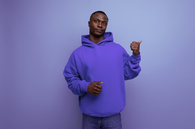 Consultor de hombre africano joven positivo enérgico en elegantes programas de sudadera con capucha con oferta real de mano en