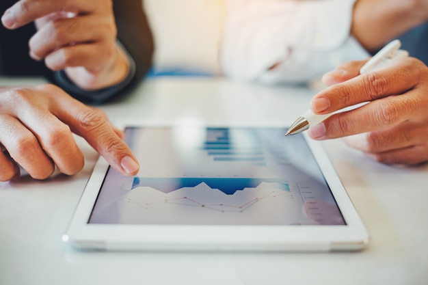 Consultor de inversiones de dos empresarios analizando el informe financiero de la empresa