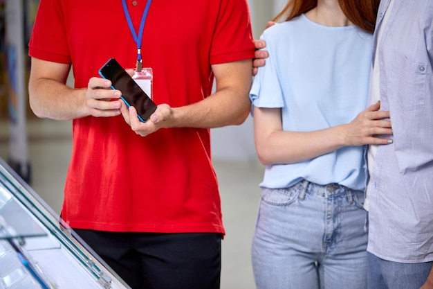 Consultor irreconhecível mostrando representando o novo modelo de smartphone moderno