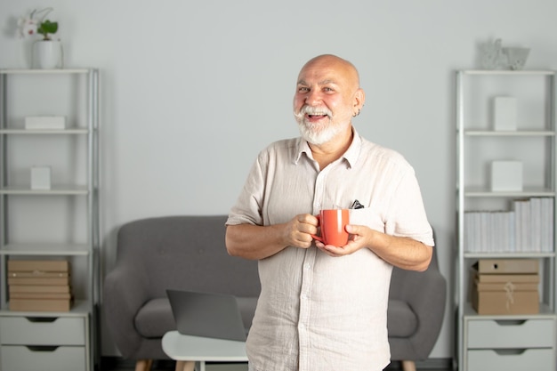 Consultor maduro senior hombre con taza de taza en la oficina