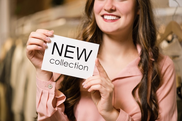 Consultor morena sonriente en la tienda con nueva etiqueta de colección