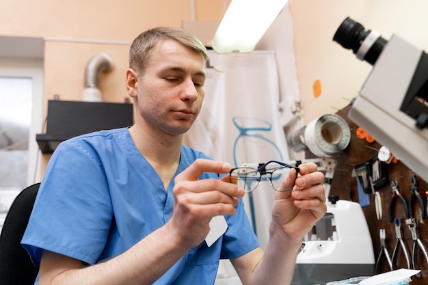 Consultor oftalmologista trabalhando com óculos Homem bonito fazendo lentes de óculos