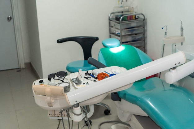 Consultório odontológico com cadeira de dentista e instrumentos dentários