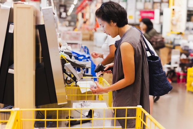 Foto consumismo femenino escaneando en el mostrador de servicio sef en una tienda de muebles