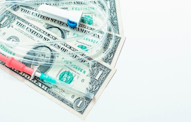 Foto conta-gotas com dólares em fundo branco. conceito de tratamento e saúde.