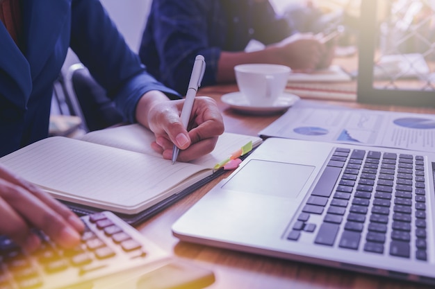 El contable de la mujer que trabaja usando la calculadora para calcula informe financiero en el lugar de trabajo.