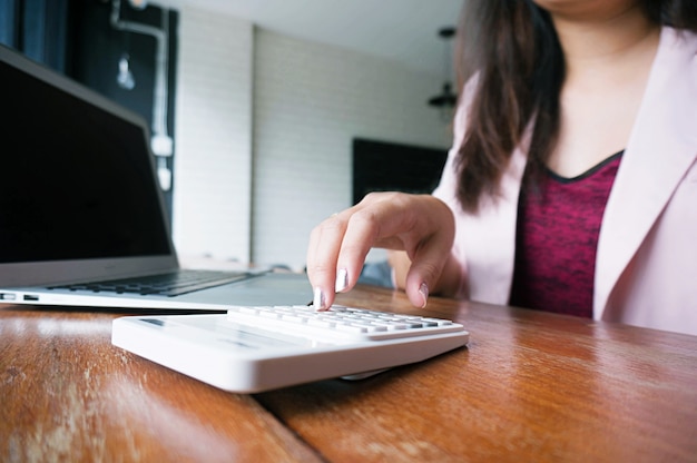 Contador As mulheres que trabalham usam a calculadora com o conceito financeiro da folha de cálculo.