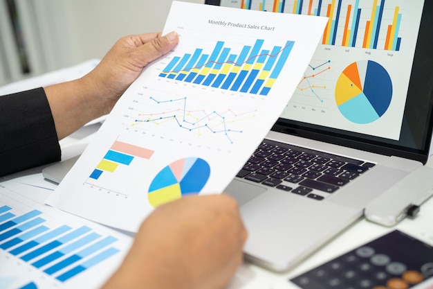 Contador asiático que trabaja y analiza la contabilidad de proyectos de informes financieros con gráficos de gráficos en el concepto moderno de finanzas y negocios de oficina