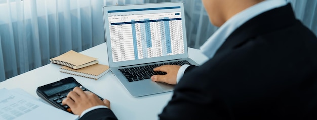 El contador corporativo utiliza software de contabilidad en su computadora portátil para calcular y maximizar los reembolsos de impuestos y mejorar el rendimiento financiero basado en datos financieros.