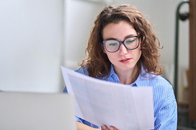 Foto contador de mujer de negocios joven con documentos que trabajan en la oficina