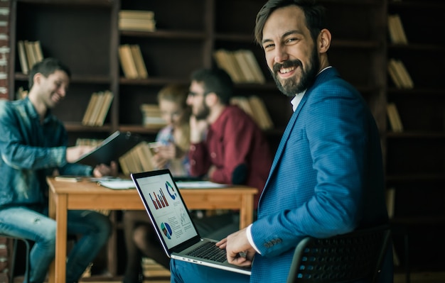 Contador trabaja con gráficos financieros en la computadora portátil en la oficina.