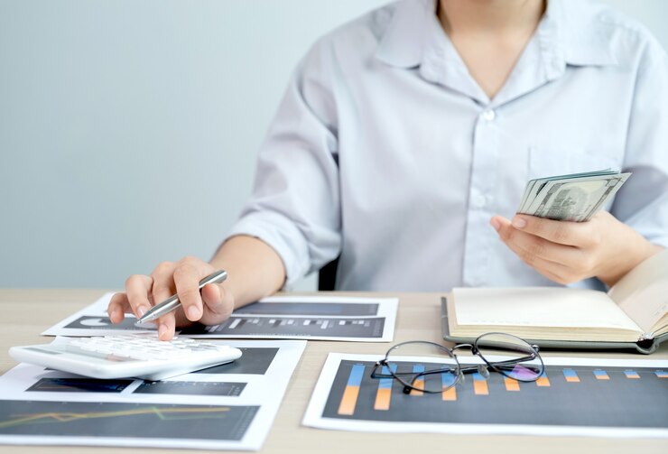 Contador usa calculadora y computadora portátil haciendo cuenta para pagar impuestos en el escritorio blanco en la oficina de trabajo.