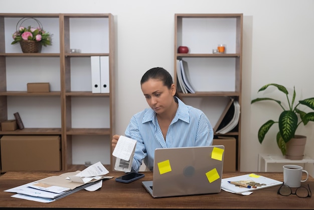 Foto contadora en el hogar calculando las finanzas usando calculadora administrando impuestos sobre la renta freelance