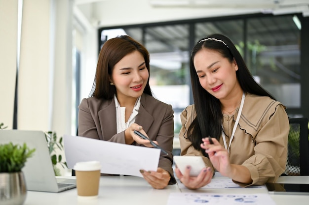 Contadores femininos estão trabalhando e analisando relatórios de dados financeiros no escritório juntos