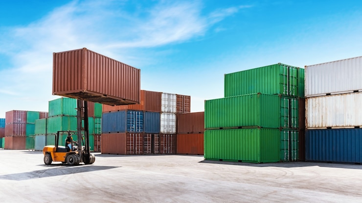 Foto container, der ladung mit gabelstapler stapelt, der im schifffahrtshafen arbeitet.