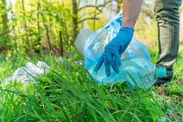 Contaminación global del planeta con residuos plásticos. Los voluntarios ayudan a la ecología limpiando bosques y prados recolectando desechos