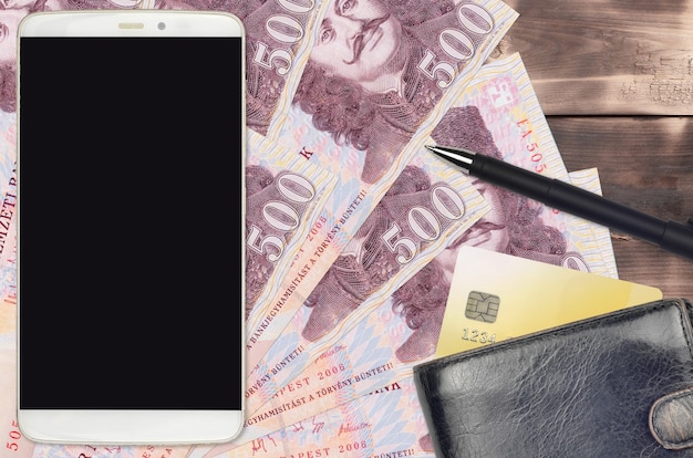 Contas de forint húngaro e smartphone com bolsa e cartão de crédito