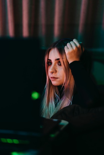 Contemplando a una mujer joven sentada en el cuarto oscuro