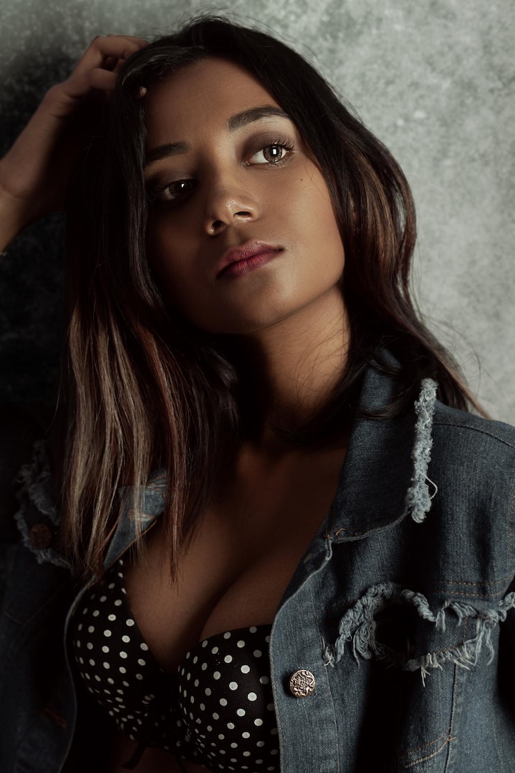 Foto contemplando uma jovem de pé contra a parede