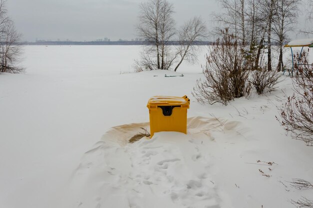 Un contenedor amarillo está cubierto de nieve y está cubierto de nieve.