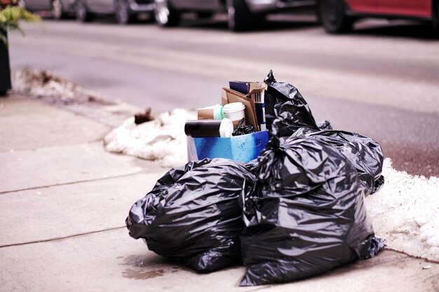 Foto un contenedor de basura en la acera de la ciudad