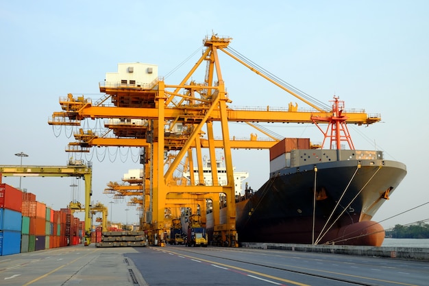 Foto contenedor, grúa gigante y buques de carga en la terminal para trabajar en la importación y exportación logística