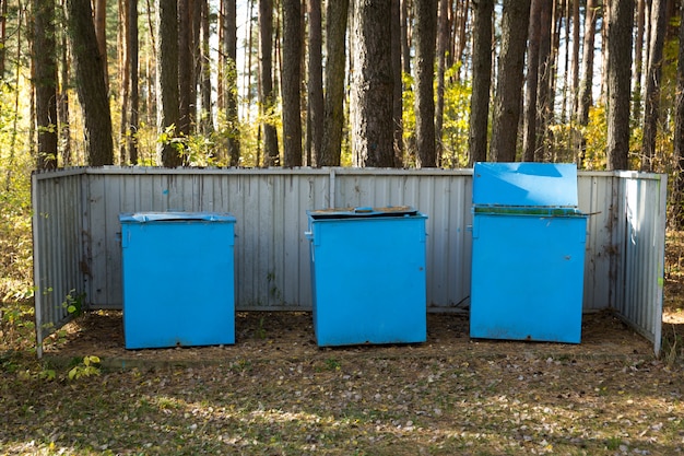 Contenedores de metal azul para recoger basura en el bosque. Recogida de residuos y ecología. Foto de alta calidad