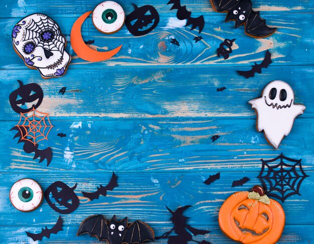 Contenido de la fiesta de Halloween. Galletas de pan de jengibre de Halloween en el fondo de madera azul.