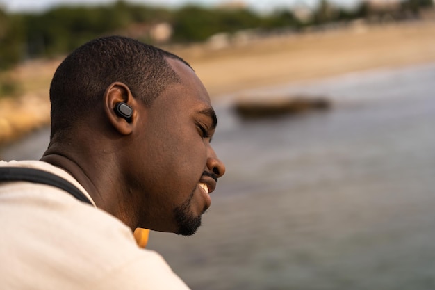 Contenido hombre negro disfrutando de la música cerca del mar