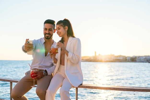 Contenido pareja étnica tomando selfie en terraplén