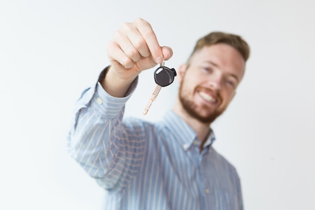 Content young man holding key to new car